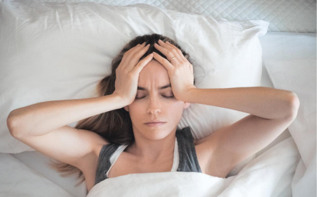 Girl in bed with hands one her head